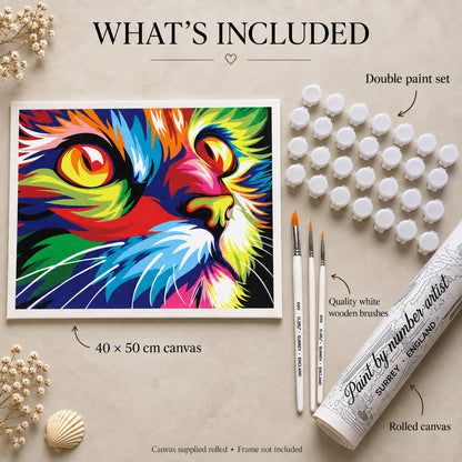 Colourful cat paint by numbers kit contents mockup showing cat artwork, paint pots, three long white wooden brushes and rolled canvas packaging on a cream surface.