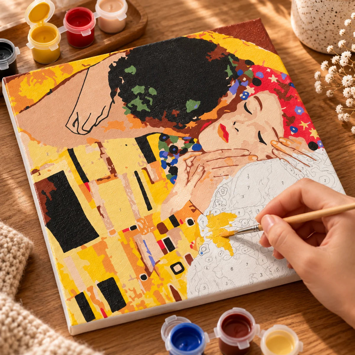 The Kiss paint by numbers canvas being painted with a wooden detail brush
