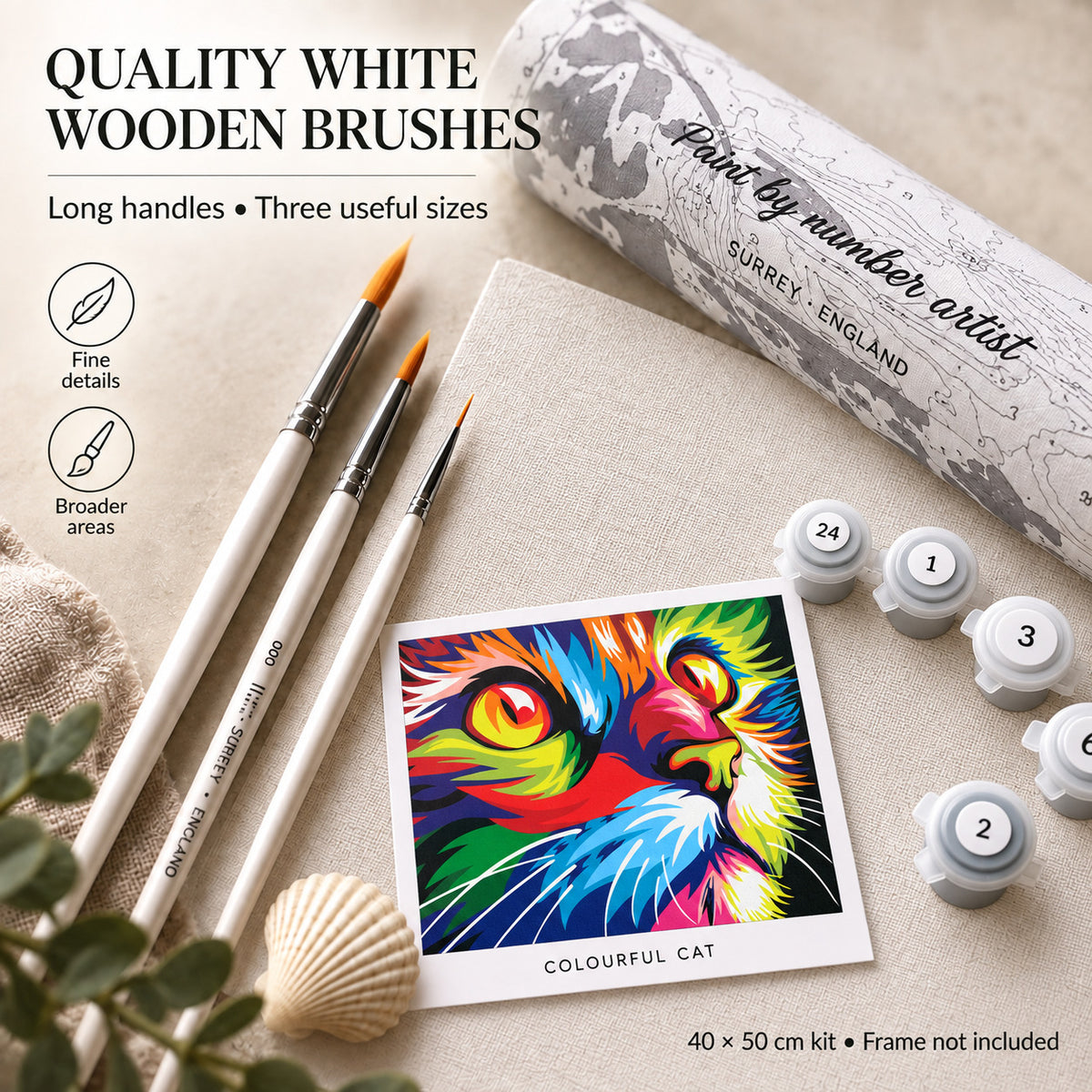 White wooden-handled brushes shown beside rolled canvas packaging, numbered paint pots and a colourful cat reference card.