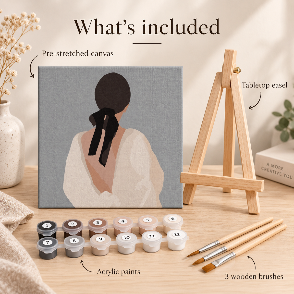 Woman with Black Bow paint by numbers kit contents with square canvas, acrylic paints, three wooden brushes and tabletop easel